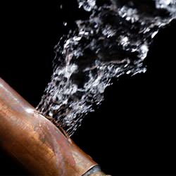 A bursting copper pipe in Duncan, with water gushing out.