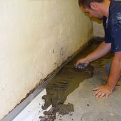 A basement waterproofer installing a perimeter drain system in Ladysmith