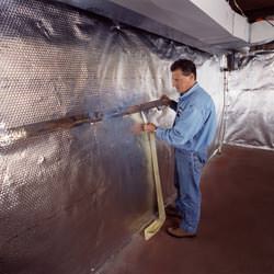 Installation of a radiant heat and vapor barrier on a basement wall in Whistler